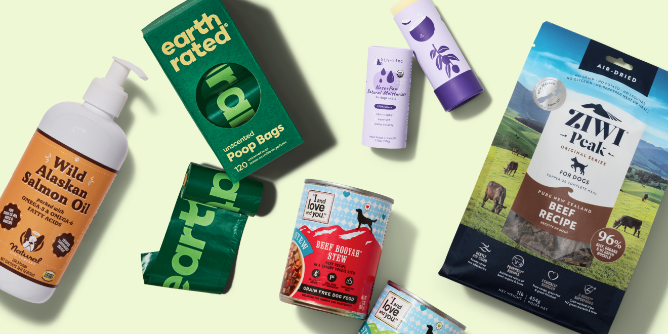 Various pet products displayed on a light green background, including salmon oil, poop bags, shampoo, dental spray, cans of beef stew, and a bag of air-dried beef dog food.