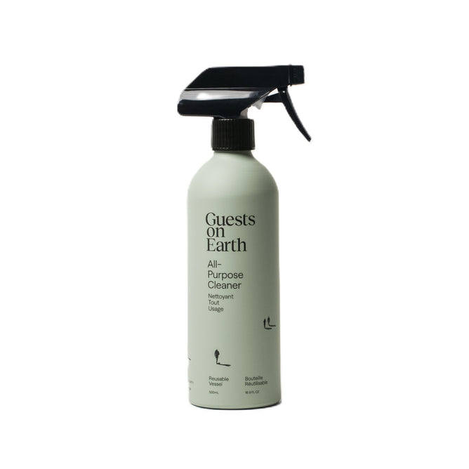 A Guests on Earth All-Purpose Cleaner spray bottle has a mint green label with simple text and icons showcasing its reusable and refillable nature, complemented by a black nozzle. Ideal for eco-conscious households seeking sustainable cleaning solutions.