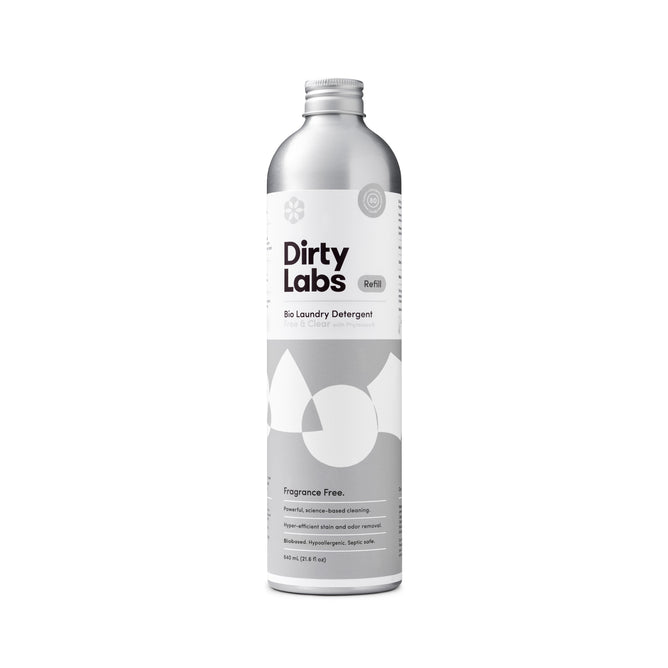 A silver bottle of Dirty Labs Bio Laundry Detergent with Phytolase® - Free & Clear, a fragrance-free formula designed for sensitive skin. The sleek container features abstract white shapes on the label, comes with a screw cap, and holds 640 mL (21.6 fl oz).