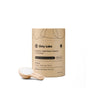 A cardboard container of Dirty Labs Probiotic Toilet Bowl Cleaner with Phytolase® is displayed beside a wooden scoop filled with white cleaning powder on a white background, emphasizing its powerful toilet bowl cleaning capabilities.