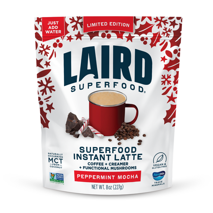 Laird Superfood Peppermint Mocha Instant Latte comes in a festive red and white pouch, featuring a red mug of latte with chocolate pieces and coffee beans. This vegan, gluten-free, freeze-dried coffee is a limited edition.