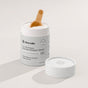 An open container of Dirty Labs 2-in-1 Bio Enzyme Dishwasher Detergent + Booster with a wooden scoop inside, placed beside its lid on a neutral background. This bioenzyme-powered formula delivers powerful cleaning and a spotless finish in every wash.