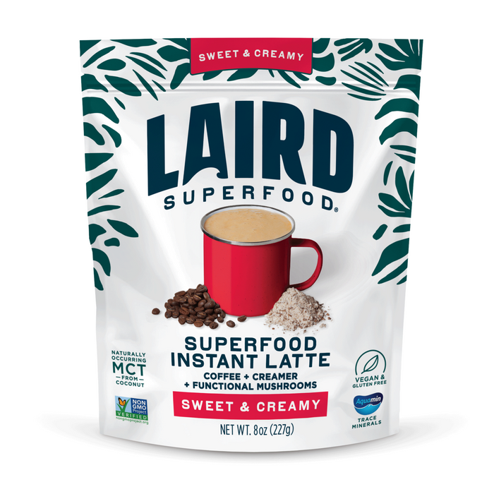 A package of Laird Superfood Sweet & Creamy Instant Latte, shown with a red mug, coffee beans, and creamer powder. The packaging notes this vegan, gluten-free latte is rich in MCTs.
