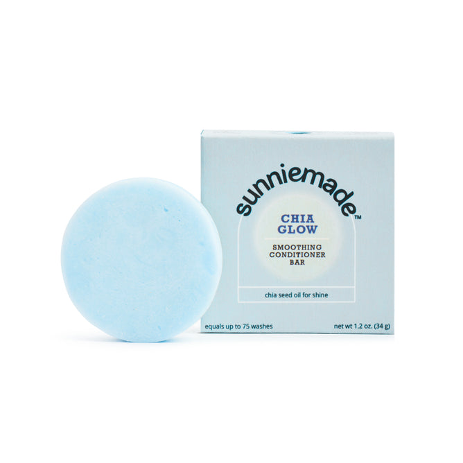 A round, light blue conditioner bar from Sunniemade, labeled “Smoothing Conditioner Bar - Chia Glow,” sits beside its box and features nourishing chia seed oil to add shine, reduce frizz, and provide up to 75 washes.