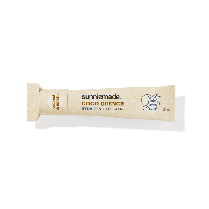 A beige tube of Sunniemade Hydrating Lip Balm – Coco Quench, infused with coconut and vanilla flavor, features minimalist line drawings of a bird and a coconut on the tube’s right side. Made with nourishing cocoa butter and packaged in recyclable materials, this lip balm offers both hydration and an eco-friendly choice.
