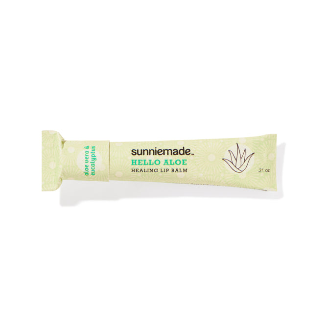 A green tube of Sunniemade Healing Lip Balm – Hello Aloe, enriched with aloe vera and eucalyptus, features a minimalist aloe plant graphic and product details on recyclable packaging.