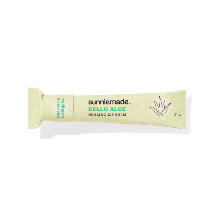 A green tube of Sunniemade Healing Lip Balm – Hello Aloe, enriched with aloe vera and eucalyptus, features a minimalist aloe plant graphic and product details on recyclable packaging.