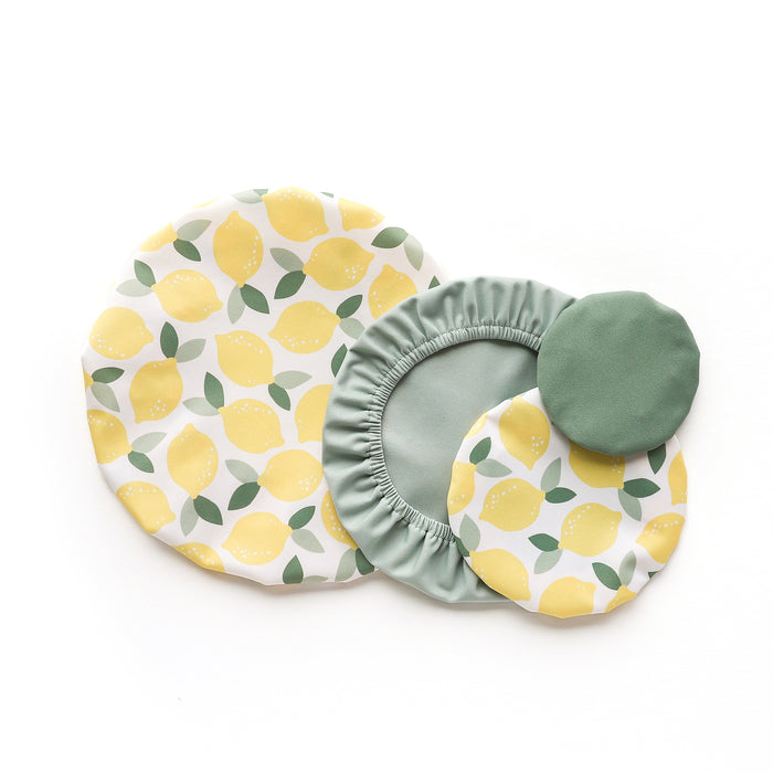 Esembly Baby Reusable Bowl Covers made from Upcycled Materials, 4-Pack, features two lemon-patterned and two solid green machine-washable covers in various sizes, stylishly overlapped on a white background for sustainable food storage.