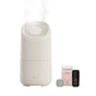 A Canopy Portable Humidifier releases mist beside a gray disk, an Unwind box, and a small dark bottle on a plain white background—ideal for hydrating your skin anywhere.