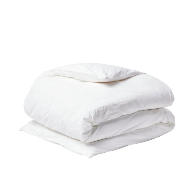A neatly folded Coyuchi Organic Crinkled Percale™ Duvet Cover in white, topped with a matching pillow, both made from breathable crinkled percale bedding, set against a plain white background.