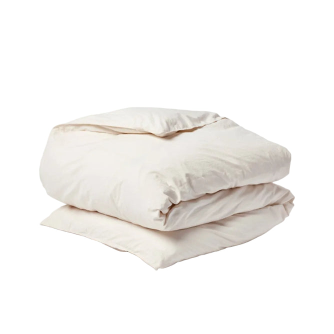 A neatly folded, light beige comforter or duvet—featuring the Coyuchi Organic Crinkled Percale™ Duvet Cover—is placed on a plain white background.
