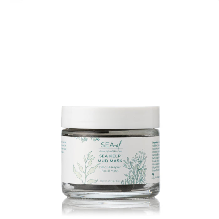 A clear glass jar labeled Sea-el Sea Kelp Mud Mask sits on a white background with green botanical illustrations, containing gray facial mask enriched with purifying clays and ocean minerals, and finished with a white lid.