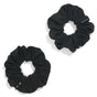 Two black KOOSHOO Scrunchies made from organic cotton are displayed diagonally on a white background. Each elasticated, plastic-free scrunchie is perfect for tying back hair.