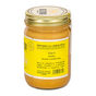 A glass jar with a gold lid contains Banana Flax Wag Butter by Big Spoon Roasters. Its yellow label reads BANANA GOLDEN FLAXSEED MEAL, highlighting the nutritional benefits of this peanut butter for dogs—a true canine superfood.