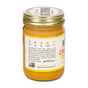 A glass jar of Big Spoon Roasters Crunchy Peanut Butter displays its golden contents, featuring a visible label with natural ingredients, batch production info, allergen icons, and a sealed gold lid.