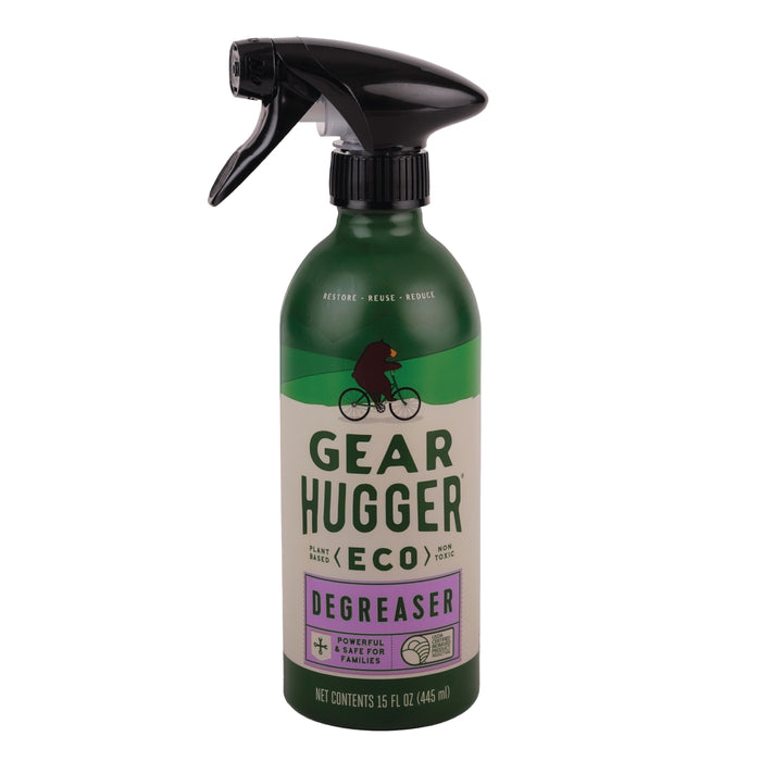 A green spray bottle labeled Gear Hugger Heavy Duty Degreaser, featuring a silhouette of a person riding a bicycle. The bottle states it is a plant-based, non-toxic degreaser and contains 15 fl oz (445 mL).