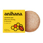 A yellow Anihana Shampoo Bar (Regular Hair) box with honeycomb and almond designs sits beside a round, beige mānuka honey shampoo bar.