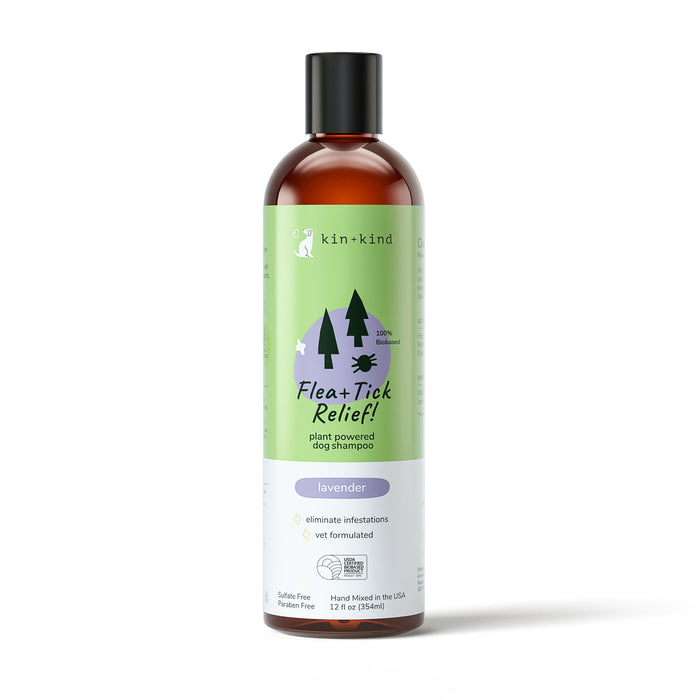 A 12 fl oz (354 ml) green bottle of kin+kind Flea+Tick Relief Dog Shampoo. Plant-powered, lavender-scented, sulfate-free, paraben-free, and vet-formulated with natural essential oils. The brown-capped bottle features a tree graphic. Ideal for dog grooming supplies.