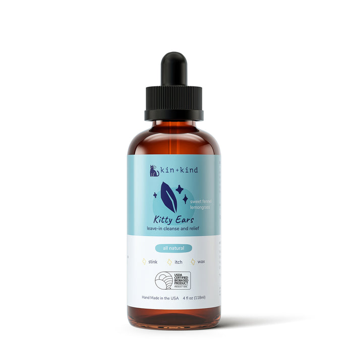 A 4 fl oz (118 mL) brown bottle with a dropper lid labeled kin+kind Kitty Ears - Leave-In Cat Ear Cleaner features icons for stink, itch, and wax, is all-natural with a sweet fennel lemongrass scent, and offers a cleanse and relief solution for cats ears.