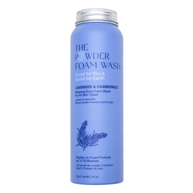 A cylindrical blue bottle labeled The Powder Foam Wash with lavender and chamomile, described as a relaxing body foam wash for all skin types, featuring an illustration of lavender flowers.