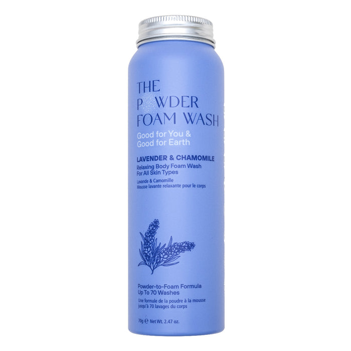 A cylindrical blue bottle labeled The Powder Foam Wash with lavender and chamomile, described as a relaxing body foam wash for all skin types, featuring an illustration of lavender flowers.