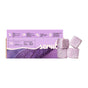 A box of Soapymania Lavender Tea Sugar Scrub Cubes sits beside four purple cubes. The vegan packaging highlights key ingredients and benefits, and features a leaf image.