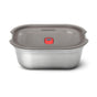 The Black + Blum Steel Food Box is a rectangular, microwaveable stainless steel container with a gray plastic lid featuring a red center button that fits securely and is leakproof.
