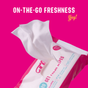A pack of Here We Flo FLO Get Fresh Body + Intimate Wipes with one wipe being pulled out sits on a bright pink background. “ON-THE-GO FRESHNESS” appears in white above and “Yay!” in yellow. Ideal for sensitive skin.