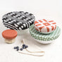 Esembly Baby’s Reusable Bowl Covers made from Upcycled Materials, 4-Pack, feature colorful geometric patterns for sustainable kitchen storage. Shown on a white speckled surface with a crochet cloth and blueberries.