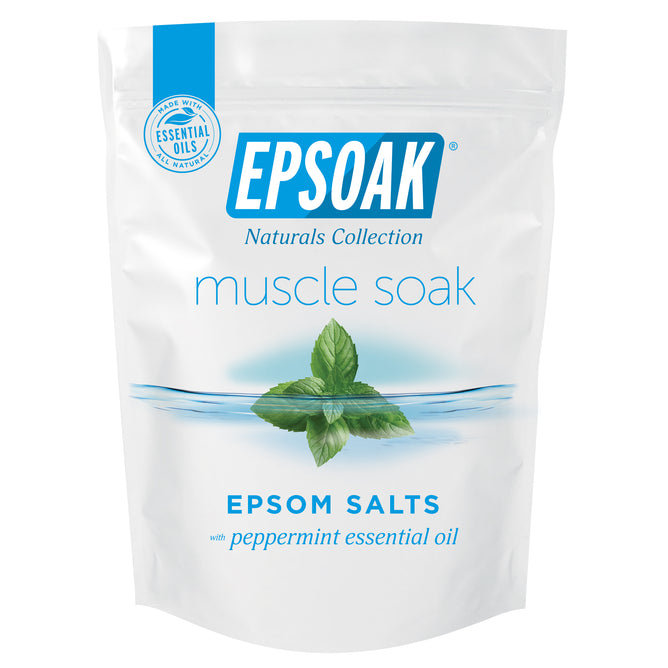A white bag labeled "Epsom Salts - Everyday Muscle Soak" by San Francisco Salt Co features a blue logo, a leaf in water, and text highlighting soothing bath salts with peppermint oil for muscle recovery.