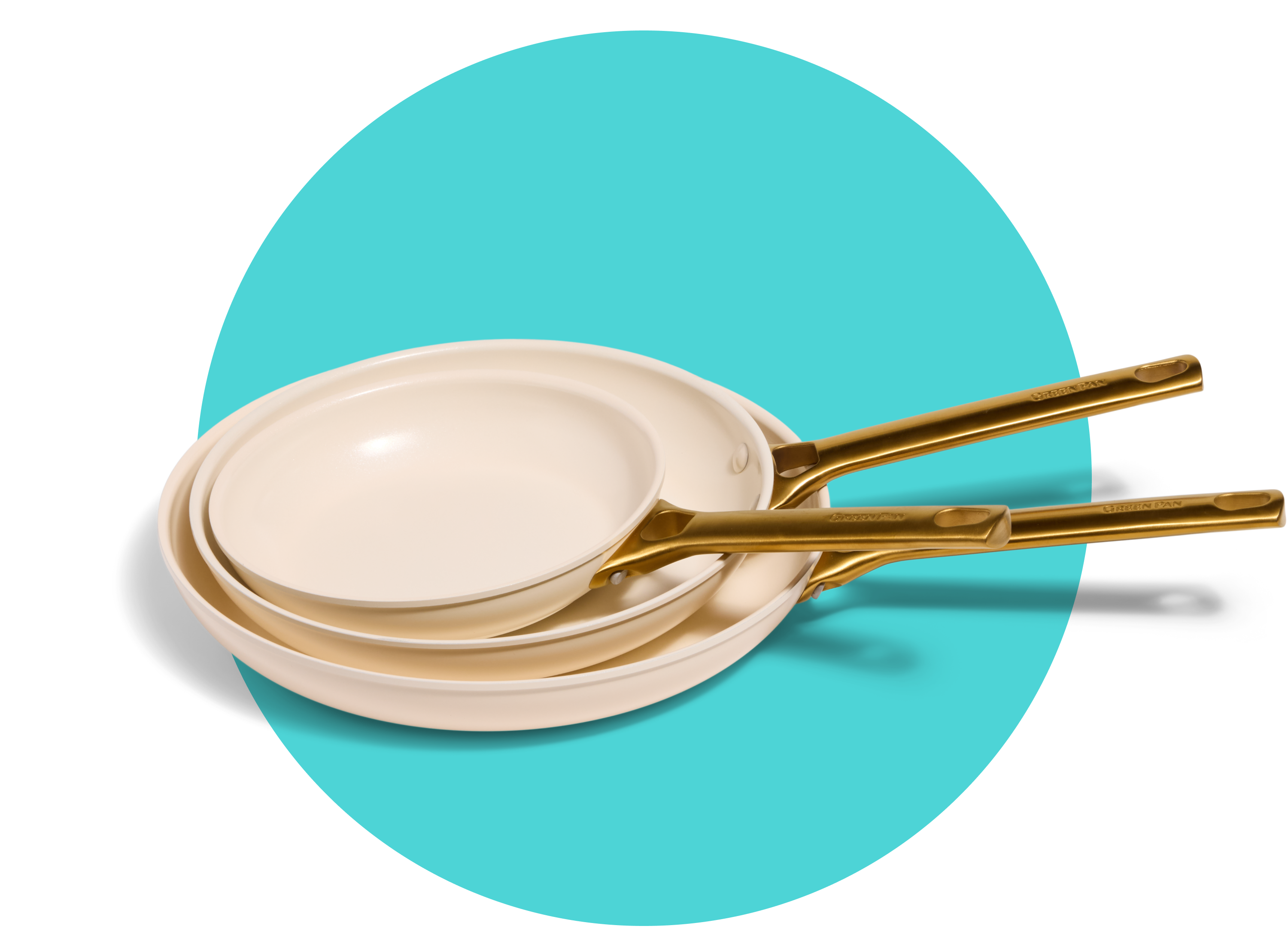 Three cream-colored frying pans with gold handles are stacked inside each other, displayed on a turquoise oval background.