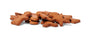 A pile of brown, human-shaped grain and gluten-free dog biscuits is scattered on a white background. Crafted with 100% whole food, human-grade ingredients by Portland Pet Food Company, these treats appear freshly baked with a matte texture.