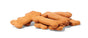 A stack of Portland Pet Food Companys Grain & Gluten-Free Dog Biscuits, made with human-grade Pacific Northwest ingredients, rests on a white surface. Shaped like light brown bones, these crunchy treats have a slightly rough texture to please any pup.