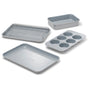 The Caraway Mini Bakeware Set w/ Storage features four non-toxic, light gray ceramic-coated essentials—a baking sheet, loaf pan, cooling rack, and six-cup muffin pan—by Caraway, arranged on a white background.