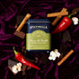 A tin of Spicewalla Deluxe Mexican Hot Chocolate sits on purple velvet, surrounded by chocolate pieces, red chili peppers, cinnamon sticks, and popcorn.