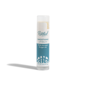 A tube of Rooted Beauty Smoothing Lip Balm - 100% Organic - Mint Flavor, with a white cap and blue label, stands upright on a white background.