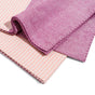 Two folded Grove Co. Large Turkish Towels from the Summer Collection, one in solid pinkish-purple and one with light pink and white stripes, are stacked on a white background with visible stitched edges.