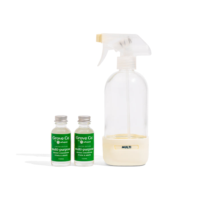 The Grove Co. Multi-Purpose Cleaner Starter Set - Summer Collection features a clear reusable spray bottle with a white nozzle labeled MULTI, next to two small glass bottles of cleaner concentrate with green labels, set against a white background.
