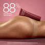 A tube of VOESH Resurfacing Sugar Scrub rests on a woman's bare thigh and hip against a pink background, with text stating 88% saw smoother skin instantly. Inspired by the Korean beauty ritual, clinical study with 34 women used daily.