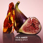 A halved fig, a whole fig, and amber sit on a reflective surface against pink, capturing Korean beauty’s luxury. Below: “VOESH Resurfacing Sugar Scrub – FIG & AMBER WARM & SPICY.”.