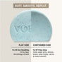 The VOESH Body Buffing Bar With AHA features flat and contoured sides: the flat side smooths skin all over, while the contoured side targets KP bumps on elbows, knees, and lower buttocks. "VOE" is embossed on its blue surface.