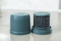A close-up of a two-part advanced water filter from Epic Water Filters USA rests on a gray surface. One part is a solid cylindrical lid, while the other shows the Nano XP Replacement Filter—an NSF certified filter—seated in its base.