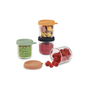 Four BEABA Glass Baby Food Jars with vibrant silicone lids hold green peas, smoothie, fruit pieces, and raspberries. One tipped jar spills raspberries—ideal for stylish homemade baby food storage.