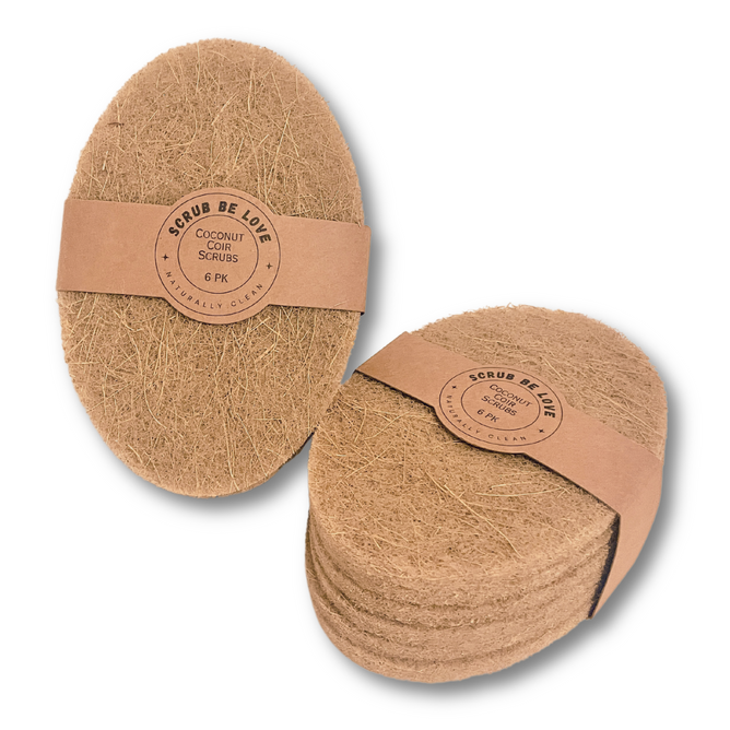 Two stacks of oval, brown Coconut Coir Dish Scrub pads from Scrub Be Love are shown in kraft bands labeled “6-Pack.” Their rough, fibrous texture makes these eco-friendly scrubbers ideal for sustainable cleaning.