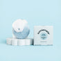 A blue Smoothing Shampoo Bar - Chia Glow from Sunniemade, topped with white foam, rests on a white dish beside its branded box against a light blue background—showcasing this plastic-free solution for gently cleansing and reducing frizz to reveal smooth, shiny hair.