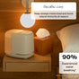 A Canopy 2.0 Bedside Humidifier (with Filter) and a box of tissues sit on a wooden nightstand by the bed. Text: “Breathe easy—moisturize airways and support immunity all season. 90% experienced easier breathing*.”.