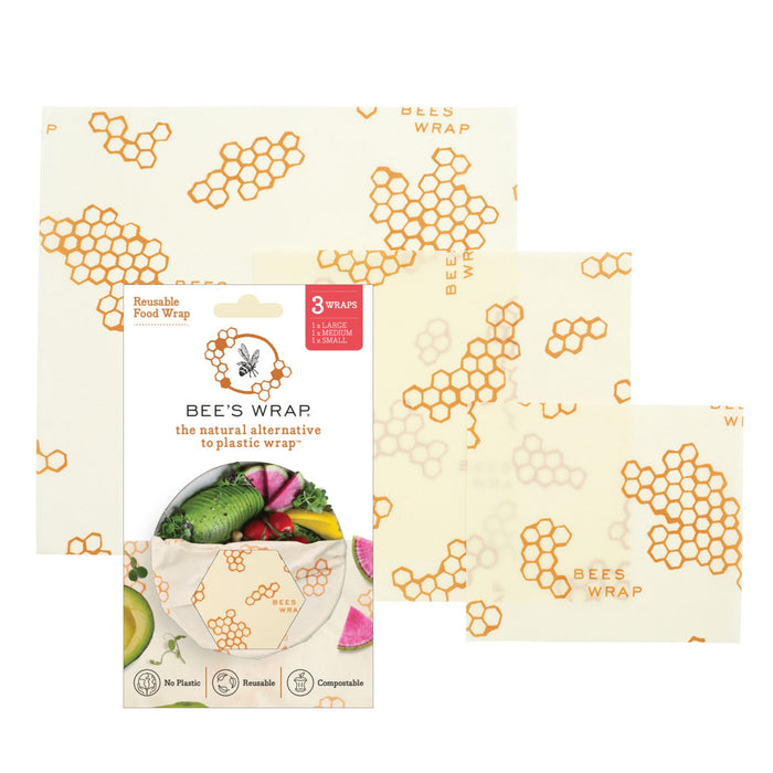 Three sheets of Bee's Wrap Reusable Beeswax Food Wraps – Assorted 3 Pack, featuring a honeycomb and bee pattern, are displayed beside their packaging as a sustainable, plastic wrap alternative.