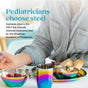 A child sits at a table with Ahimsa's Purposeful Plate, a stainless steel, pediatrician-designed dinner plate that's non-toxic and kid-friendly, alongside a matching bowl and cup filled with fruit and bread.