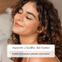 A woman with curly hair smiles softly with closed eyes, highlighting clear, healthy skin. Overlaid text: “Canopy 2.0 Bedside Humidifier (with Filter) supports a healthy skin barrier—dermatologist-recommended protection.”.