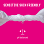 A white towel with a droplet hangs against a pink background. "Sensitive Skin Friendly" appears above, highlighting plant-based care. Below, a white scale icon reads "pH balanced." Product: FLO Get Fresh Body + Intimate Wipes by Here We Flo.